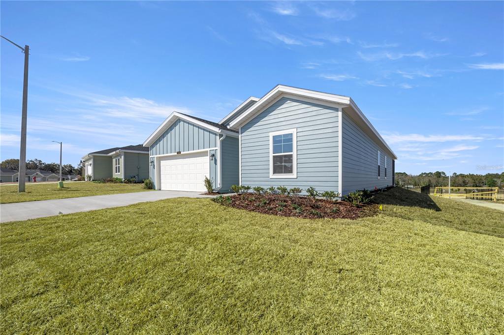 A light blue single-story house with a white garage and a grassy front yard — 3254 NE 38TH LANE, OCALA, FL