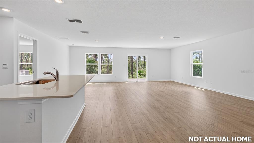 This is a rendering of an open-concept kitchen and living area with light wood-look flooring — 244 HAWTHORN AVENUE, PALM COAST, FL