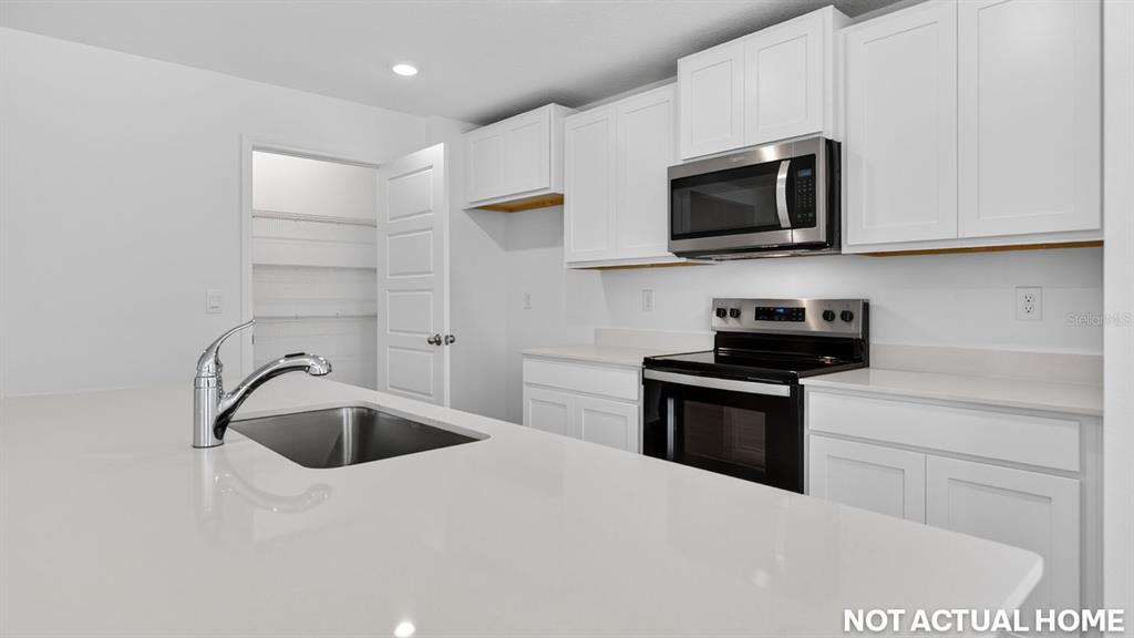 This is a rendering of a modern kitchen featuring white cabinets and stainless steel appliances — 244 HAWTHORN AVENUE, PALM COAST, FL