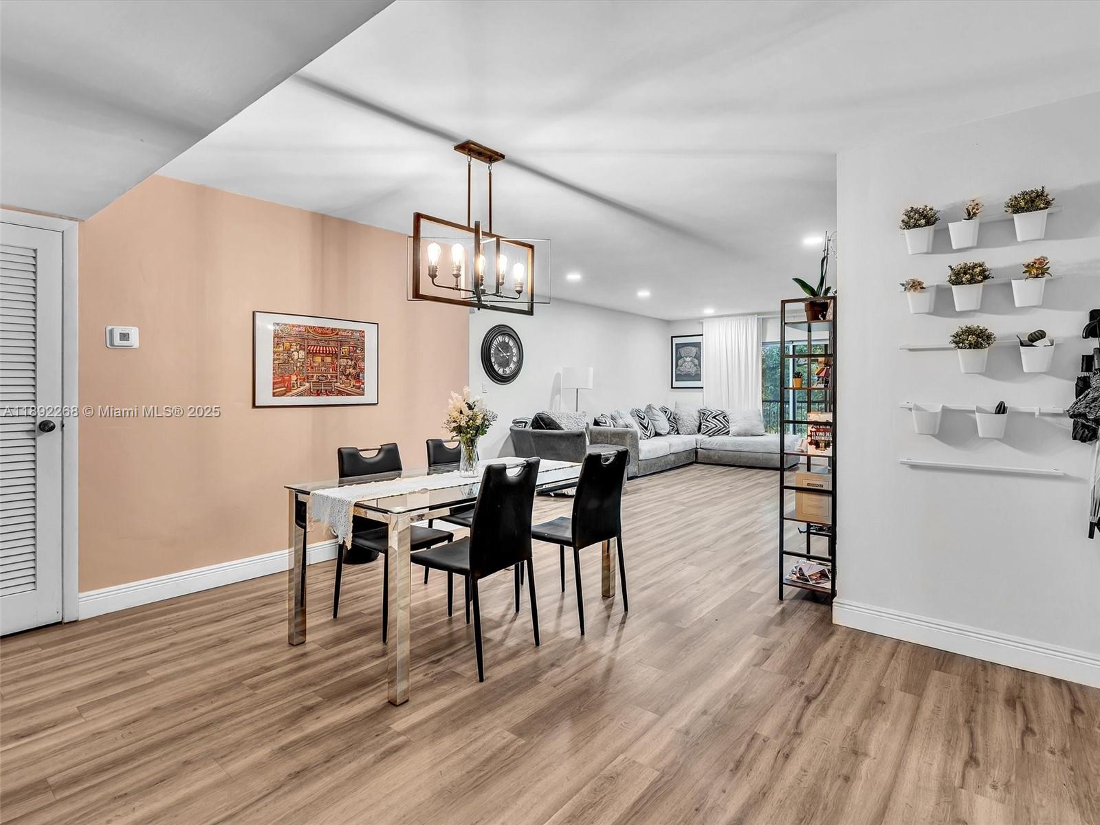 A dining area with a glass table and black chairs opens into a living room — 6061 N Falls Cir Dr # 407, Lauderhill FL 33319, LAUDERHILL, FL