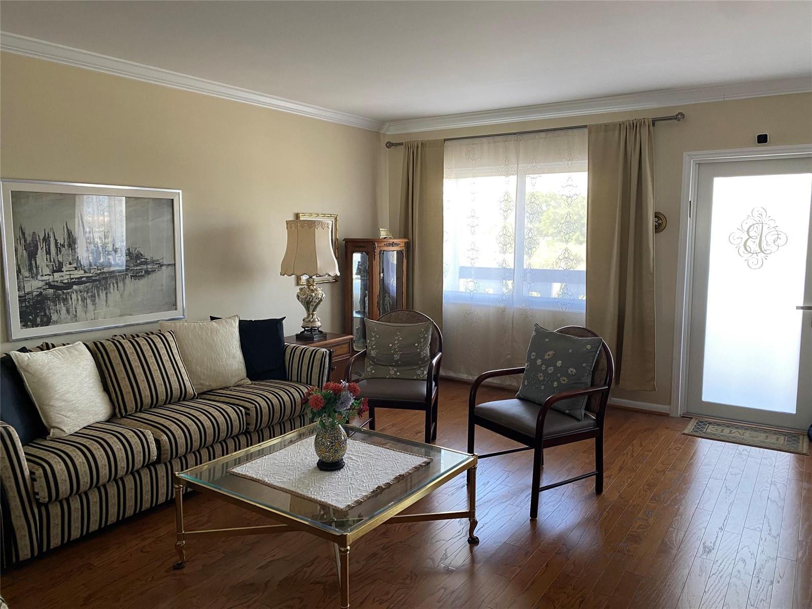 A living room features a striped sofa, glass coffee table, two chairs, and hardwood floors — 4011 Upminster J # 4011, Deerfield Beach FL 33442, DEERFIELD BEACH, FL