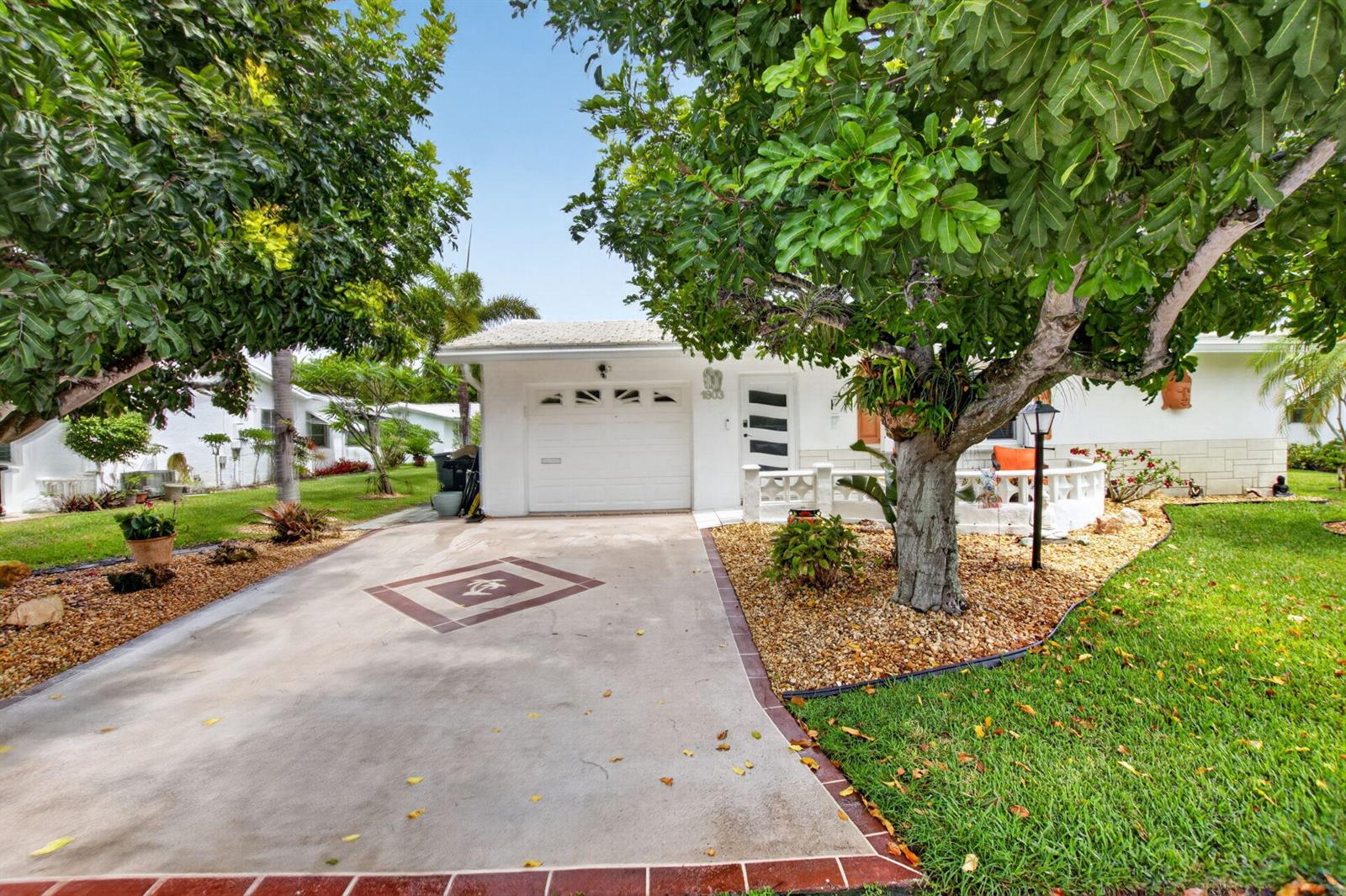A white house with a garage, a paved driveway, and a large tree in front — 1803 SW 22nd Way, Boynton Beach FL 33426, BOYNTON BEACH, FL