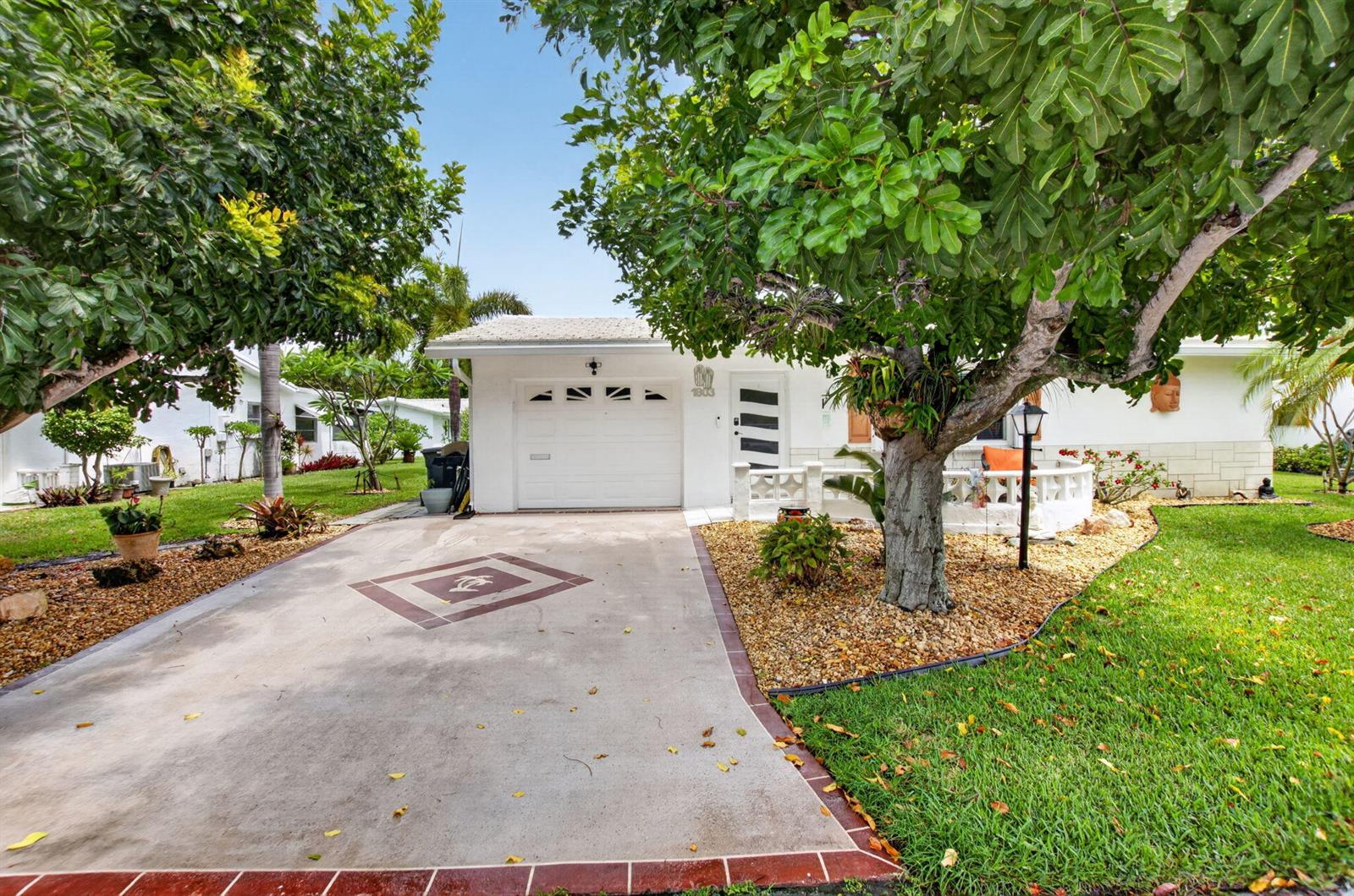 A white single-story house with a concrete driveway and a large tree in the yard — 1803 SW 22nd Way, Boynton Beach FL 33426, BOYNTON BEACH, FL