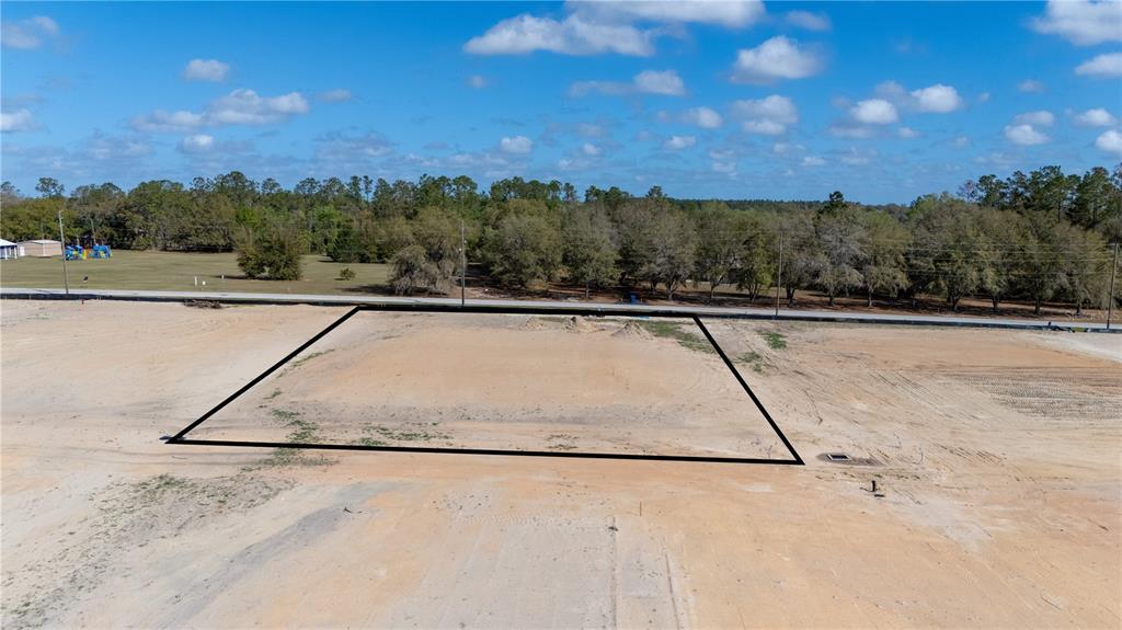 An aerial view shows a cleared, rectangular plot of land outlined in black — 32854 DUNNE ROAD, SAN ANTONIO, FL