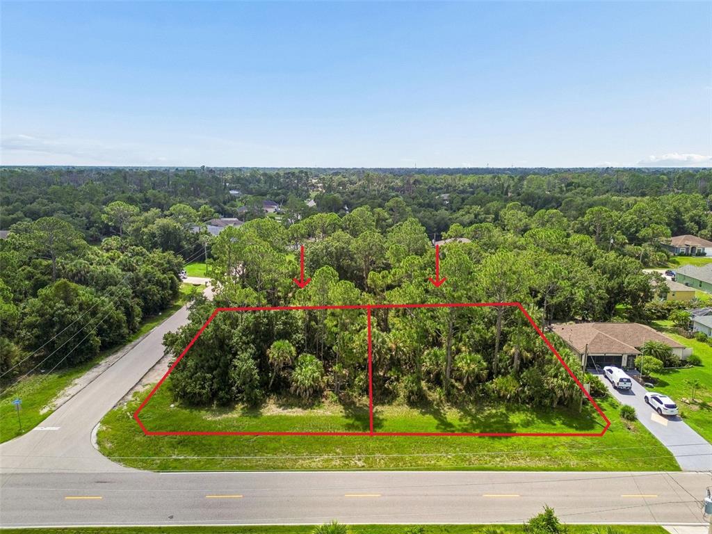 An aerial view shows two adjacent, wooded vacant lots outlined in red along a road — 14 S CHAMBERLAIN BOULEVARD, NORTH PORT, FL