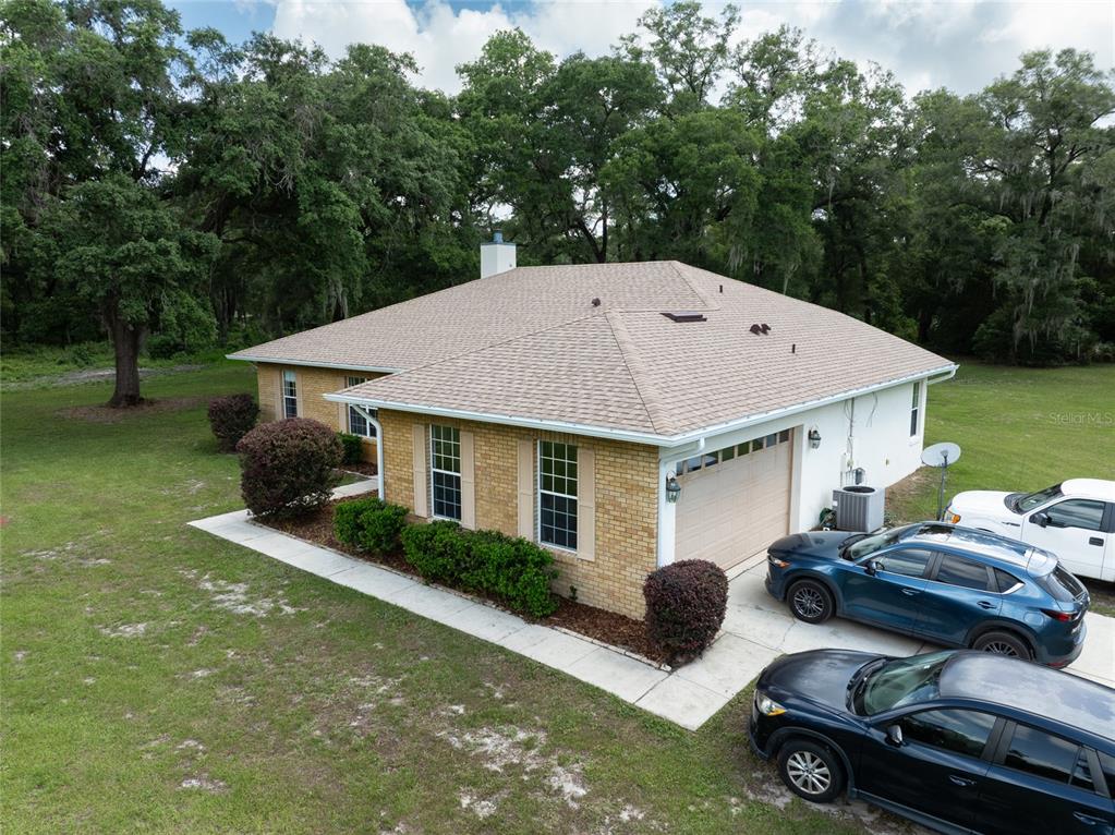 An aerial view of a single-story brick house with a garage and a shingled roof — 2698 GOOD HOMES ROAD, DELAND, FL