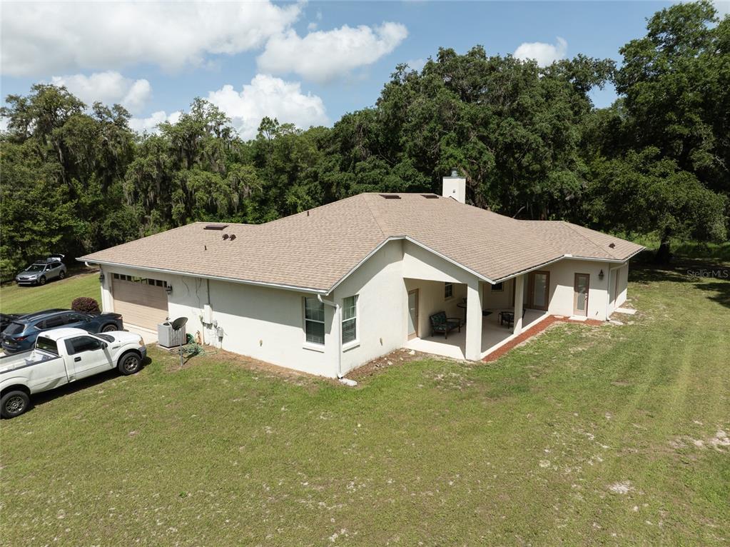 An aerial view of a single-story house with a tan roof and a covered patio — 2698 GOOD HOMES ROAD, DELAND, FL