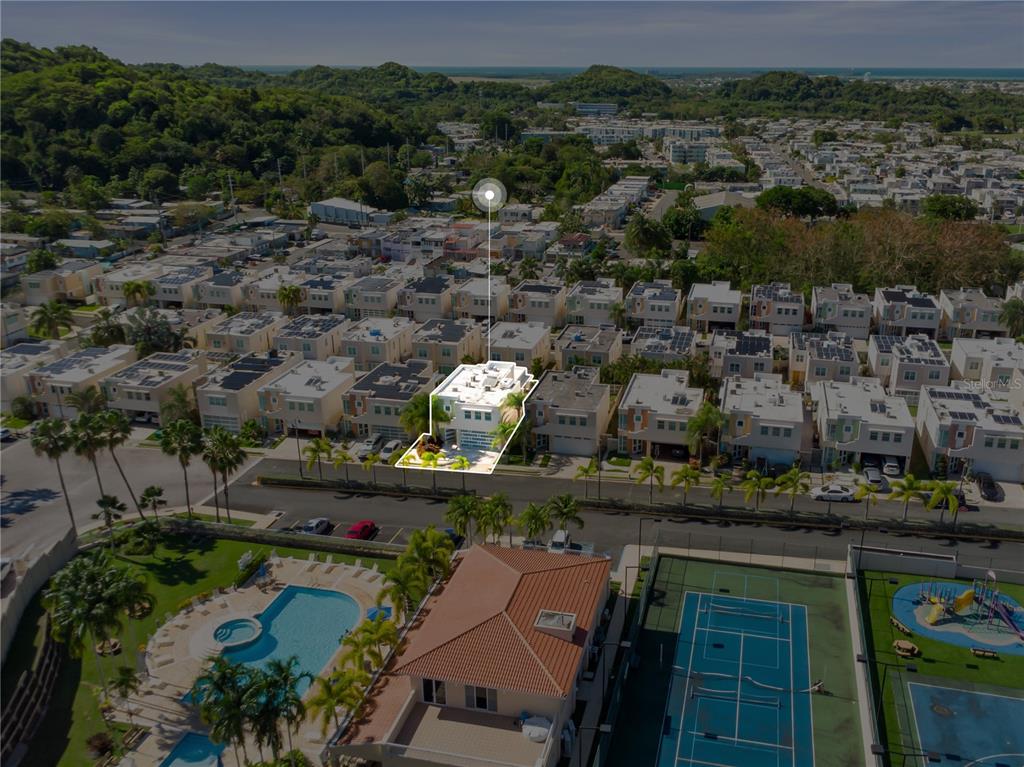 An aerial view of a residential neighborhood highlighting a specific house with a swimming pool — Urb Mirabella Village CALLE NACAR UNIT A7, BAYAMON, PR