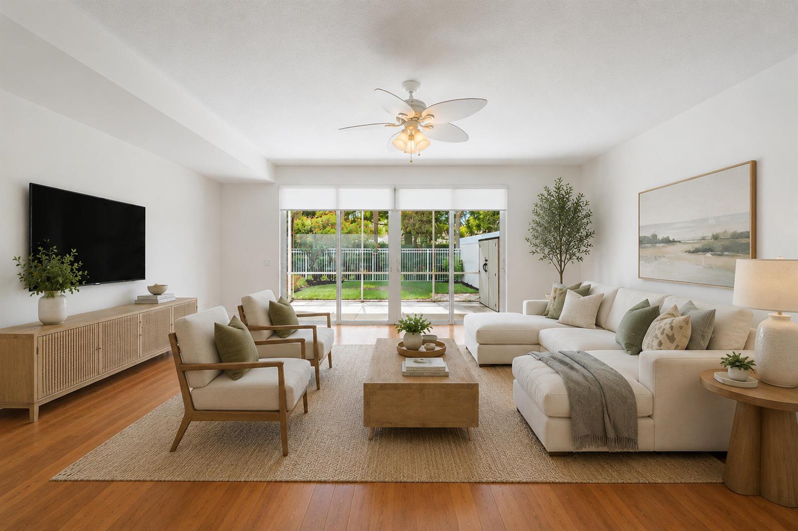 A bright living room features a white sectional, two armchairs, a wooden coffee table, and patio doors — 442 Capistrano Drive, Palm Beach Gardens FL 33410, PALM BEACH GARDENS, FL