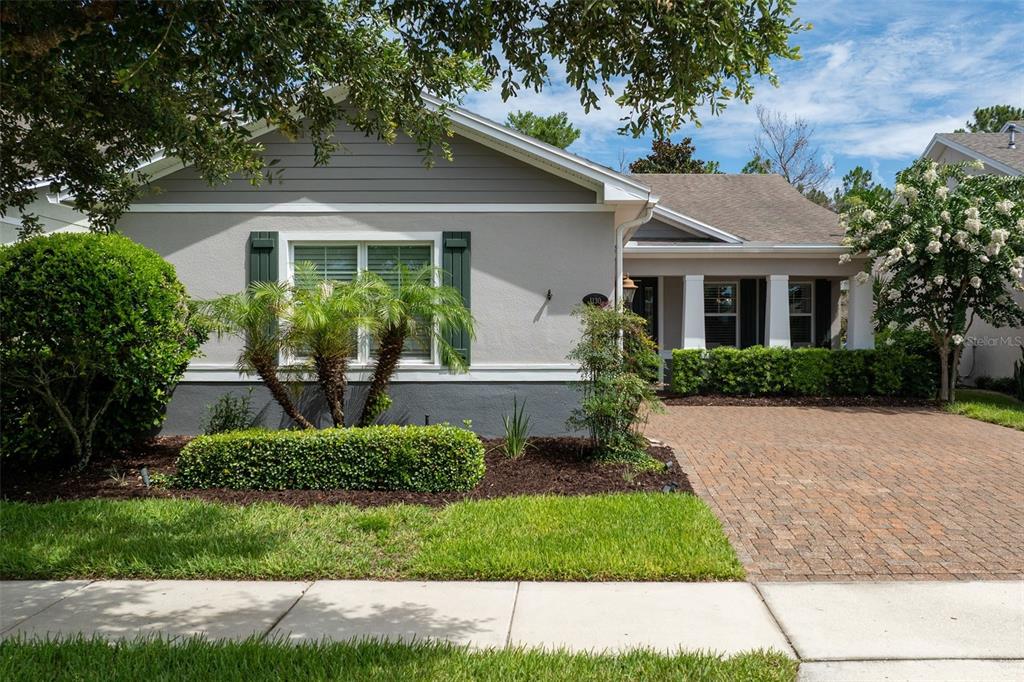 A single-story house with a gray exterior, green shutters, and a brick-paved driveway — 1130 GARDENSHIRE LANE, DELAND, FL