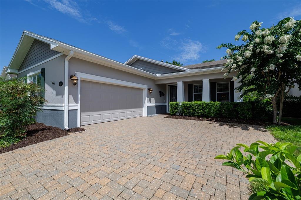 A single-story house with a paved driveway, two-car garage, and a landscaped front yard — 1130 GARDENSHIRE LANE, DELAND, FL