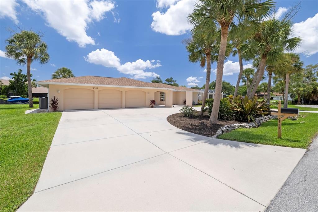 A single-story house with a three-car garage and palm trees in the front yard — 6755 AVENUE B, SARASOTA, FL