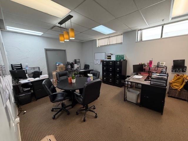 An office space features a round meeting table, multiple desks, filing cabinets, and carpeted flooring — 663 HAROLD AVENUE, WINTER PARK, FL