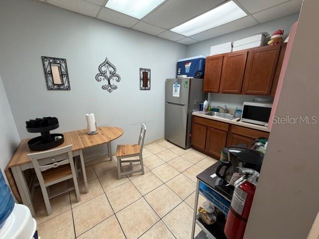A small break room features a wooden table, two chairs, a refrigerator, and wooden cabinets — 663 HAROLD AVENUE, WINTER PARK, FL