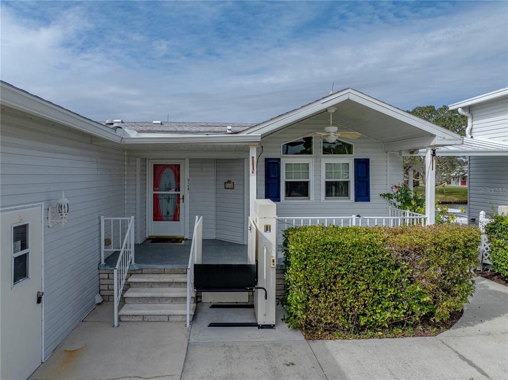 A light-gray mobile home exterior features a front porch, stairs, and a wheelchair lift — 5148 ISLAND VIEW CIRCLE N, POLK CITY, FL