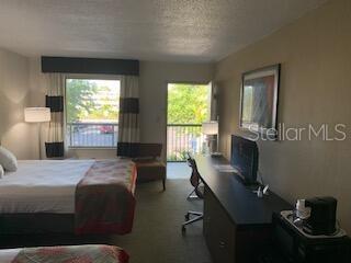 A hotel room features two beds, a desk with a television, and a balcony door — 7150 N TAMIAMI TRAIL UNIT S-604, SARASOTA, FL