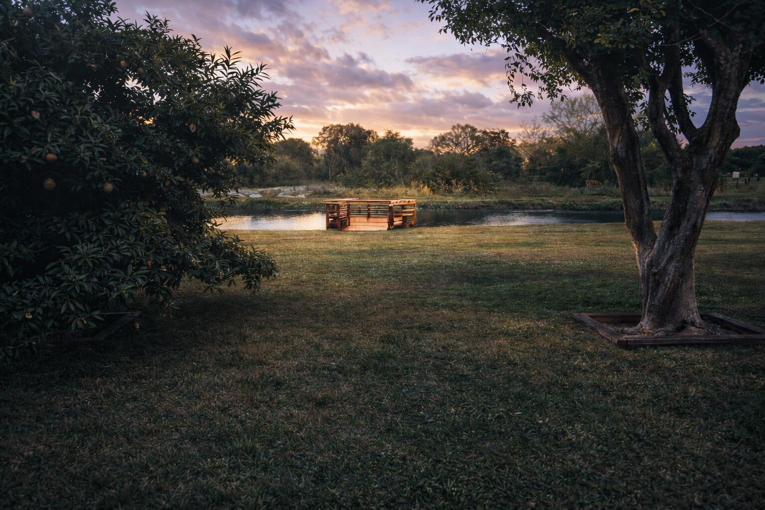 A wooden deck sits on the grassy bank of a river at sunset — 3526 Elizabeth Road, FL 33461, FL