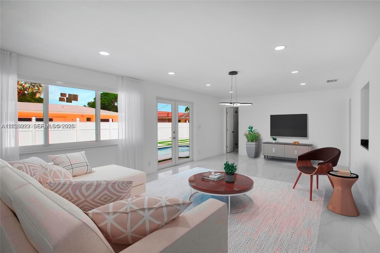 This living room features white walls, tile flooring, a sectional sofa, and a television — 1825 NE 197th Ter, Miami FL 33179, MIAMI, FL