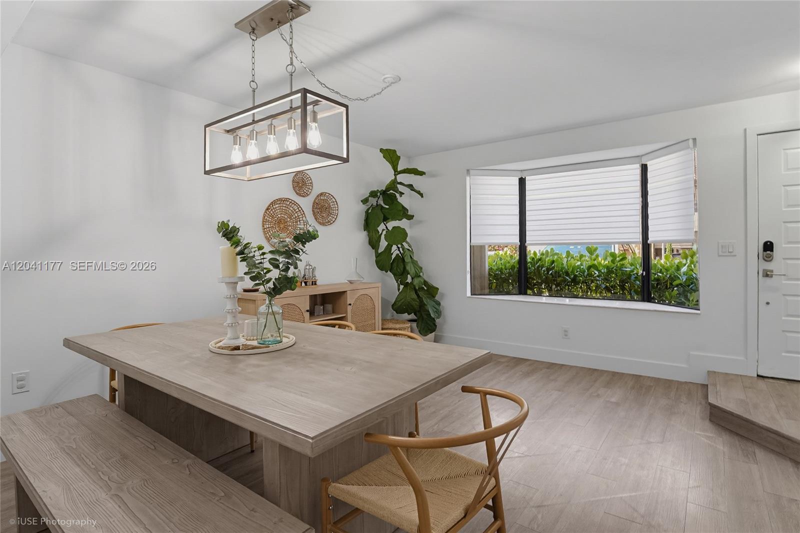 A dining room features a wooden table, a rectangular pendant light, and a bay window — 10137 SW 77th Ct, Miami FL 33156, MIAMI, FL