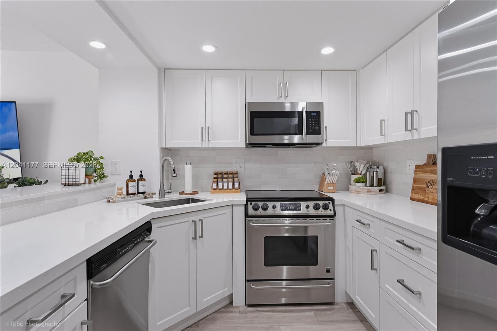 A modern kitchen features white cabinets, stainless steel appliances, and white quartz countertops — 10137 SW 77th Ct, Miami FL 33156, MIAMI, FL