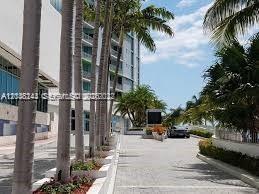 A paved driveway leads to a modern apartment building lined with tall palm trees — 335 S Biscayne Blvd # 2006, Miami FL 33131, MIAMI, FL
