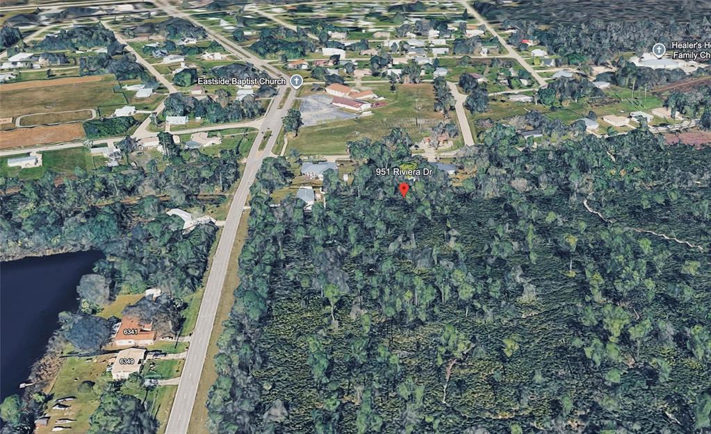 This is an aerial map view showing a residential property surrounded by trees and nearby roads — 951 RIVIERA DRIVE, PUNTA GORDA, FL