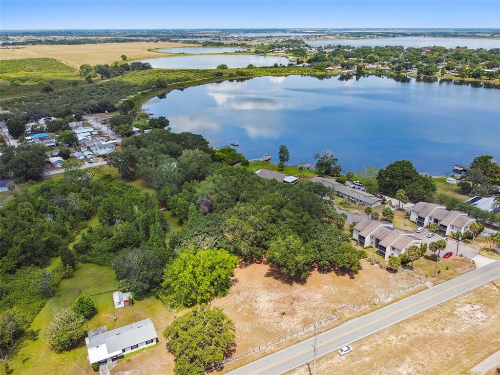 An aerial view shows a vacant lot next to a road, trees, and a lake — 1080 S BUENA VISTA DRIVE, LAKE ALFRED, FL