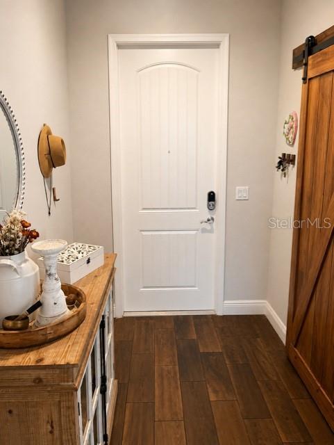 An entryway features a white door, a wooden console table, and a sliding barn door — 1194 PAISLEY COURT, LAKE WORTH, FL