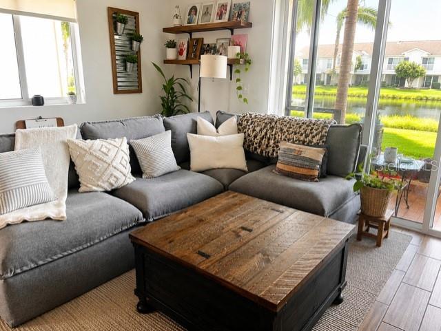 A living room features a gray sectional sofa, a wooden coffee table, and a lake view — 1194 PAISLEY COURT, LAKE WORTH, FL