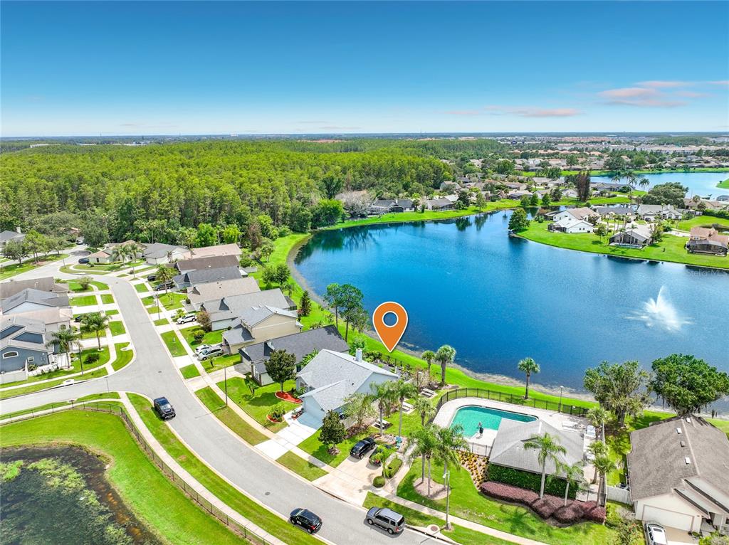 An aerial view shows a suburban house with a pool beside a large lake — 2405 SETTLERS TRAIL, ORLANDO, FL