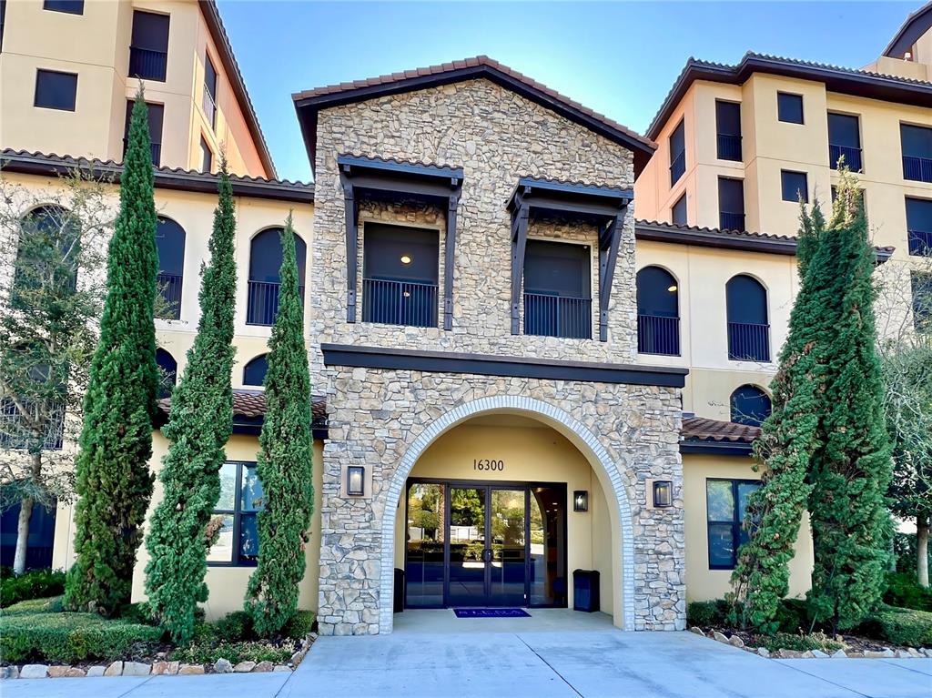 The exterior of a multi-story building features a stone-faced entrance with an arched doorway — 16300 COUNTY ROAD 455 UNIT 513, MONTVERDE, FL