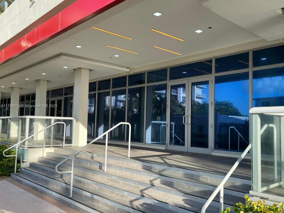 The exterior of a building features a set of concrete stairs leading to glass doors — 777 N Ocean Dr # N107, Hollywood FL 33019, HOLLYWOOD, FL