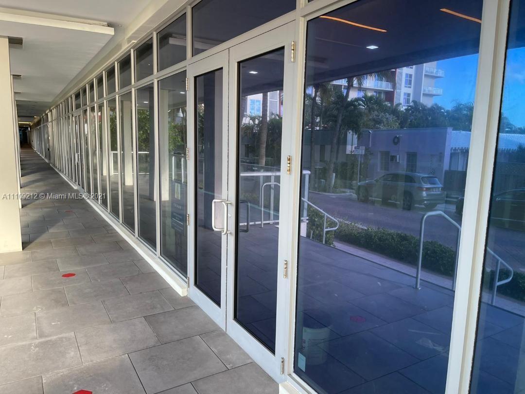 A long outdoor walkway features tiled flooring and a wall of glass doors and windows — 777 N Ocean Dr # N107, Hollywood FL 33019, HOLLYWOOD, FL