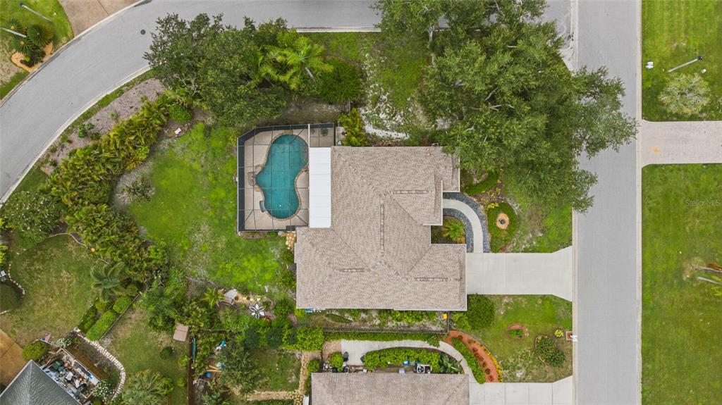 An aerial view shows a house with a screened-in pool and a driveway on a corner lot — 3732 COUNTRYSIDE ROAD, SARASOTA, FL