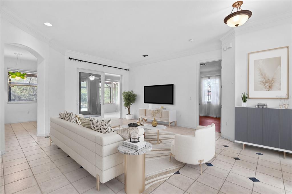 A bright living room features white tile floors, a neutral sofa, and a wall-mounted television — 3732 COUNTRYSIDE ROAD, SARASOTA, FL