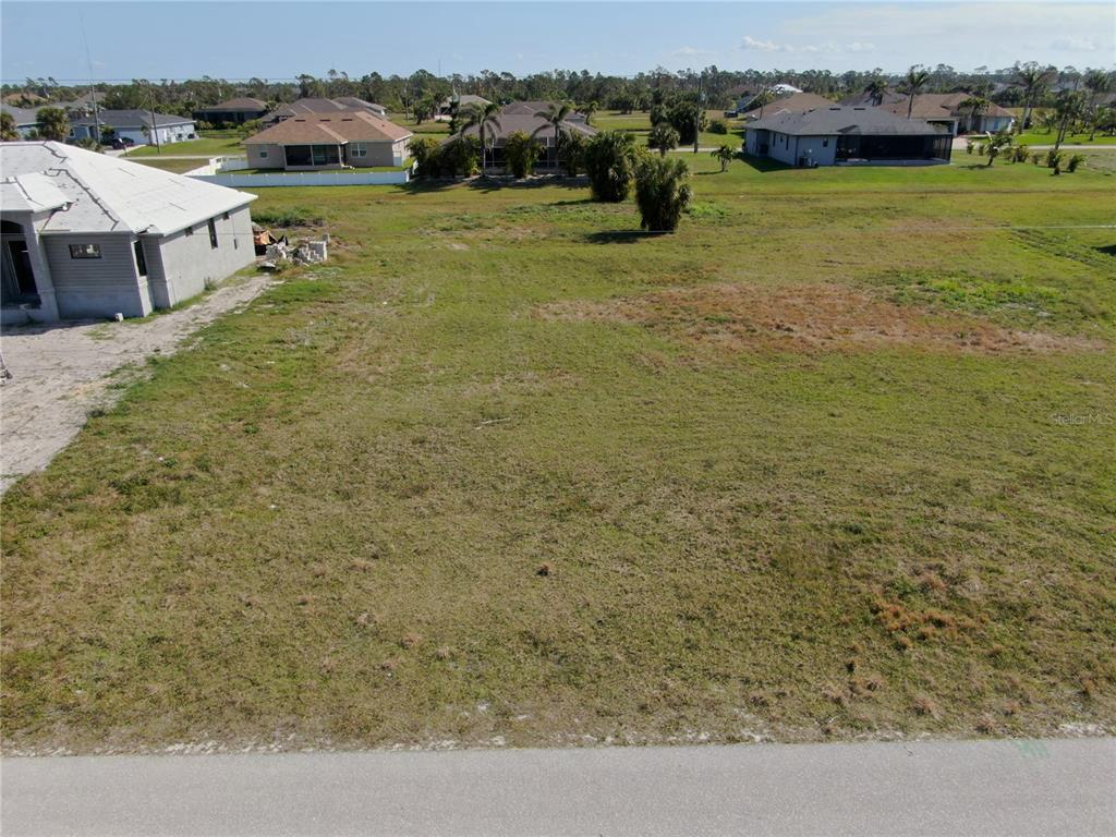 An aerial view shows a vacant, grassy residential lot situated between two existing houses — 189 ROTONDA BOULEVARD S, ROTONDA WEST, FL