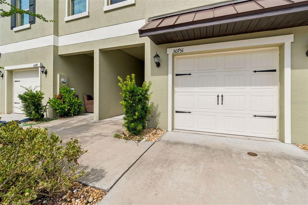 The exterior view shows two garage doors with decorative hardware and a shared entryway — 30751 VERIDIAN WAY, WESLEY CHAPEL, FL