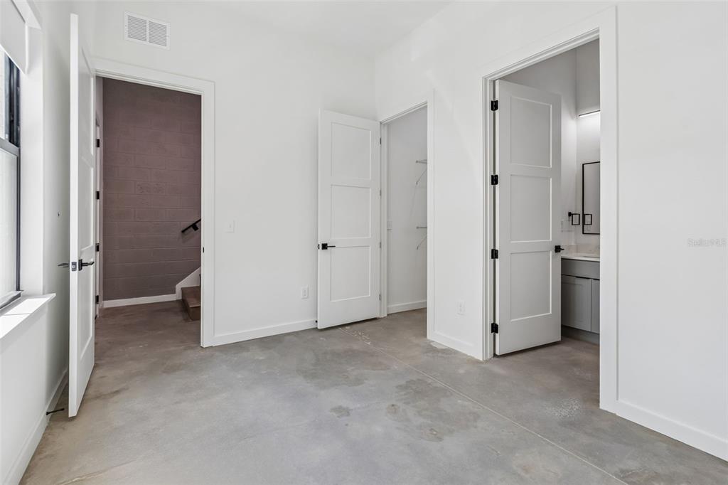 A room with concrete floors, white walls, and three open doorways leading to other spaces — 1218 E KAY STREET UNIT 21, TAMPA, FL