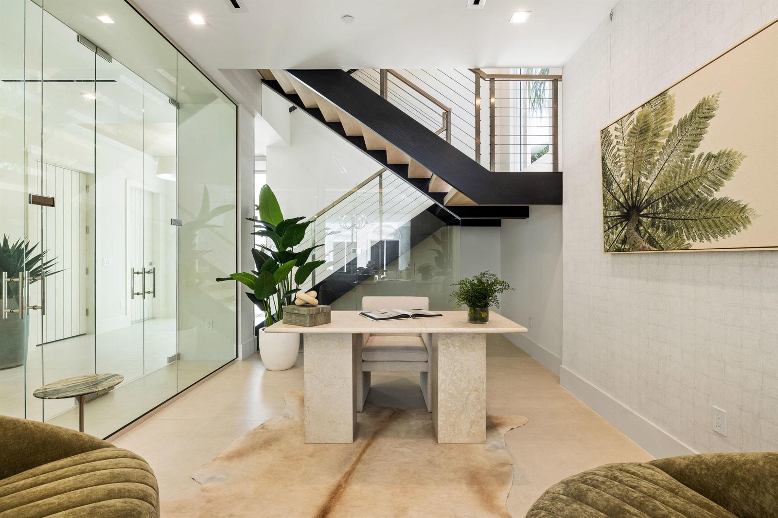 A modern home office features a stone desk, glass walls, and a staircase — 812 Palm Trail, Delray Beach FL 33483, DELRAY BEACH, FL