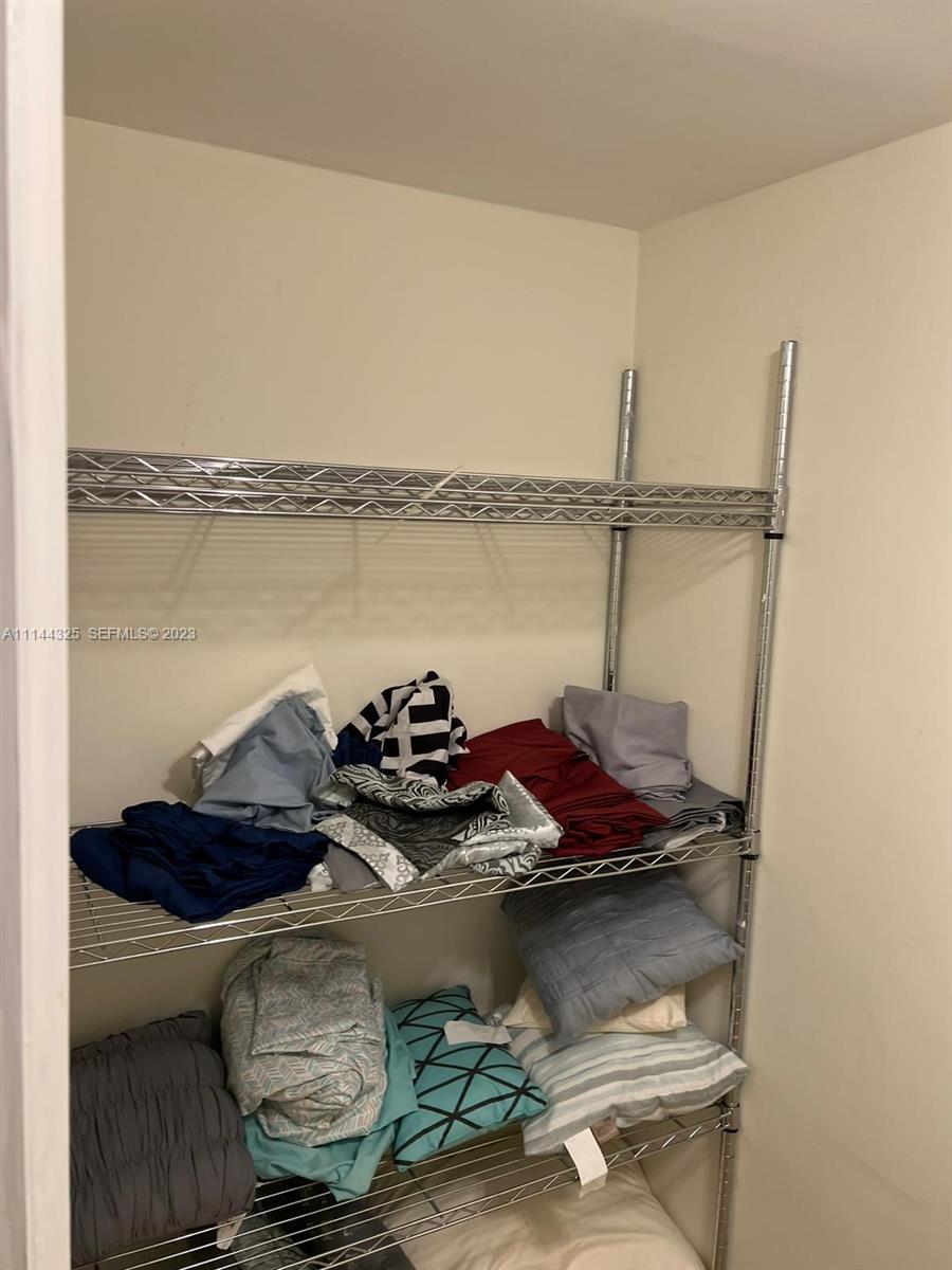 A wire shelving unit holds folded linens and pillows inside a small closet — 3725 S Ocean Dr # 301, Hollywood FL 33019, HOLLYWOOD, FL