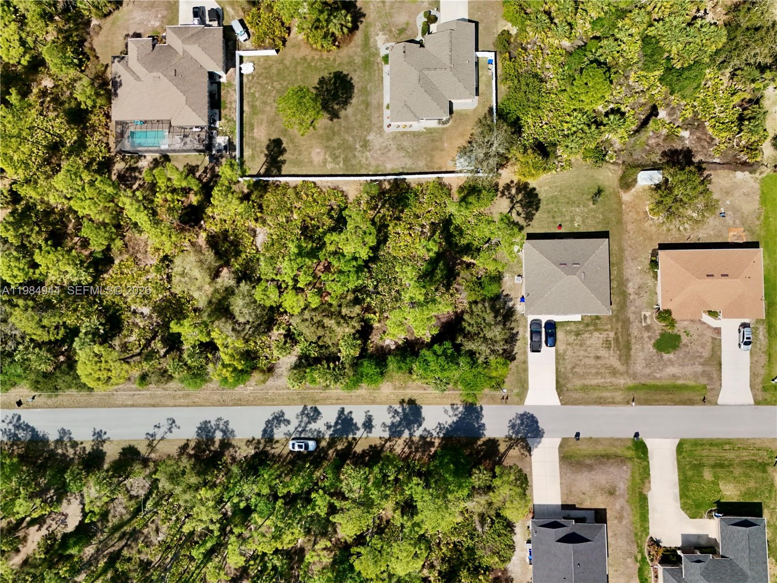 An aerial view shows several houses with driveways and pools surrounded by dense wooded areas — 0 APOLLO AVE, North Port FL 34286, NORTH PORT, FL