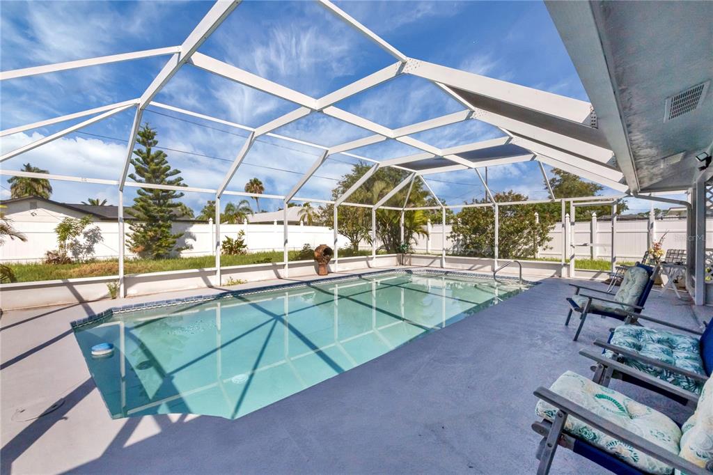 A screened-in swimming pool with a concrete deck and patio furniture under a white enclosure — 2339 LAKE VIEW BOULEVARD, PORT CHARLOTTE, FL
