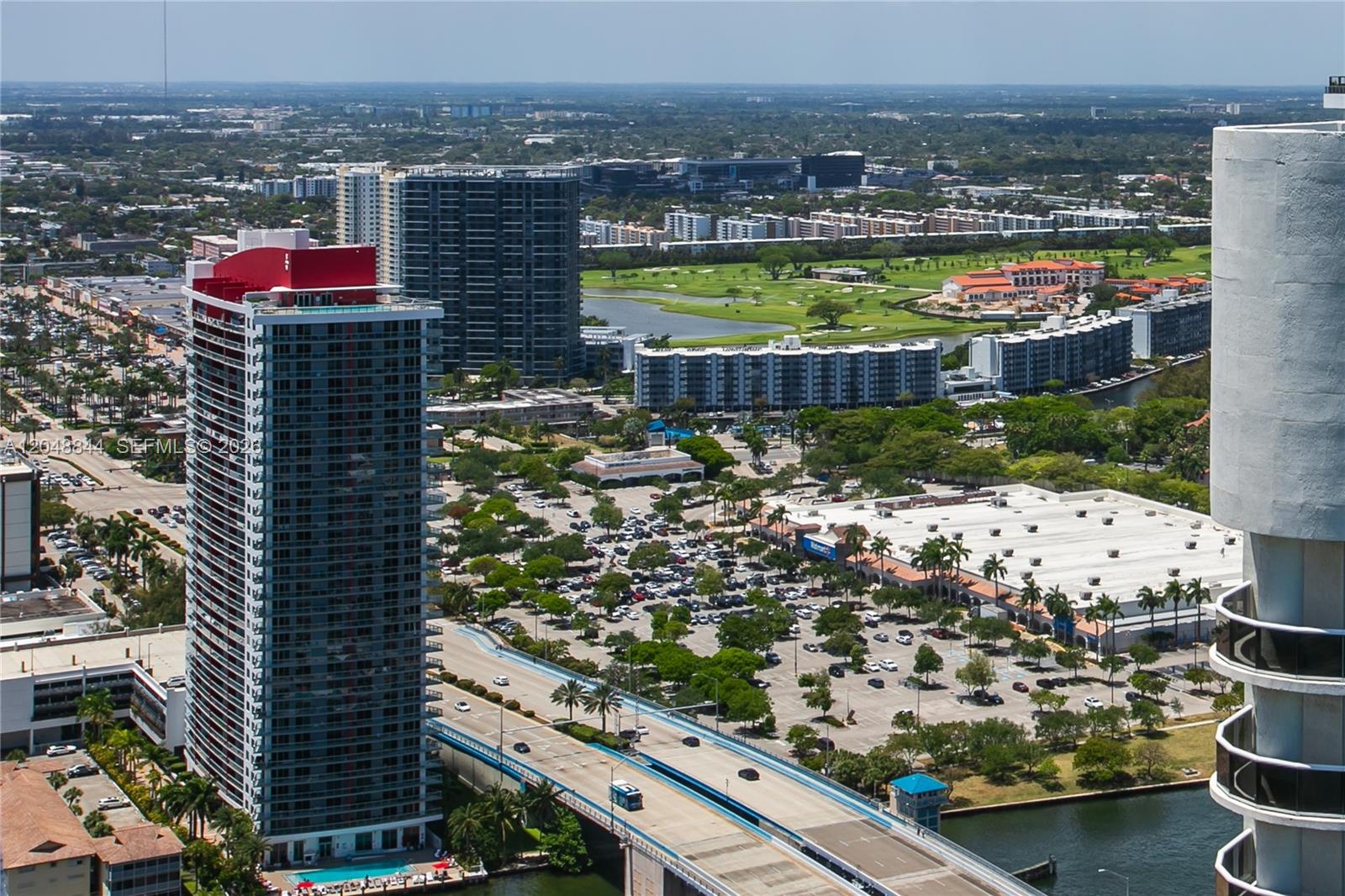An aerial view shows a tall residential tower, a bridge, and a large parking lot — 1830 S Ocean Dr # 4812, Hallandale Beach FL 33009, HALLANDALE BEACH, FL