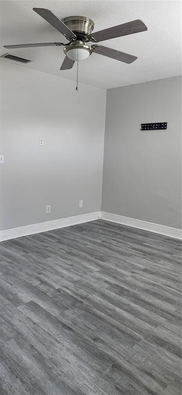 An empty room with gray walls, wood-look flooring, and a ceiling fan — 205 W AMELIA AVENUE UNIT A, TAMPA, FL