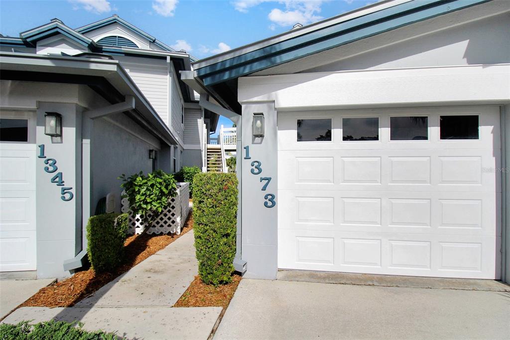 Two adjacent residential garage doors with house numbers displayed on the exterior pillars — 1373 SIESTA BAYSIDE DRIVE UNIT 1373-C, SARASOTA, FL