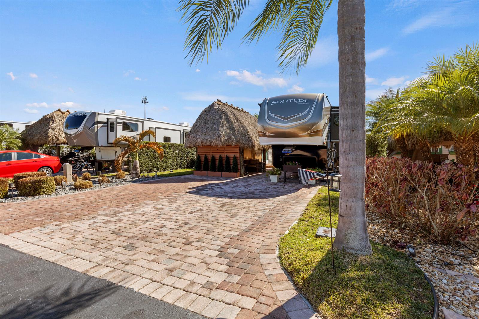 A paved driveway leads to two parked fifth-wheel trailers and a tiki hut structure — 532 SW 38th Trace, Okeechobee FL 34974, OKEECHOBEE, FL