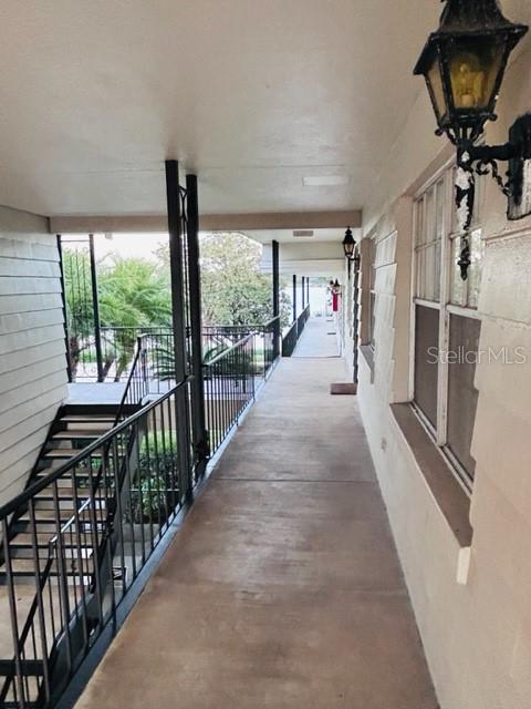 An outdoor covered walkway features a concrete floor, metal railings, and wall-mounted lanterns — 2887 S OSCEOLA AVENUE UNIT D, ORLANDO, FL