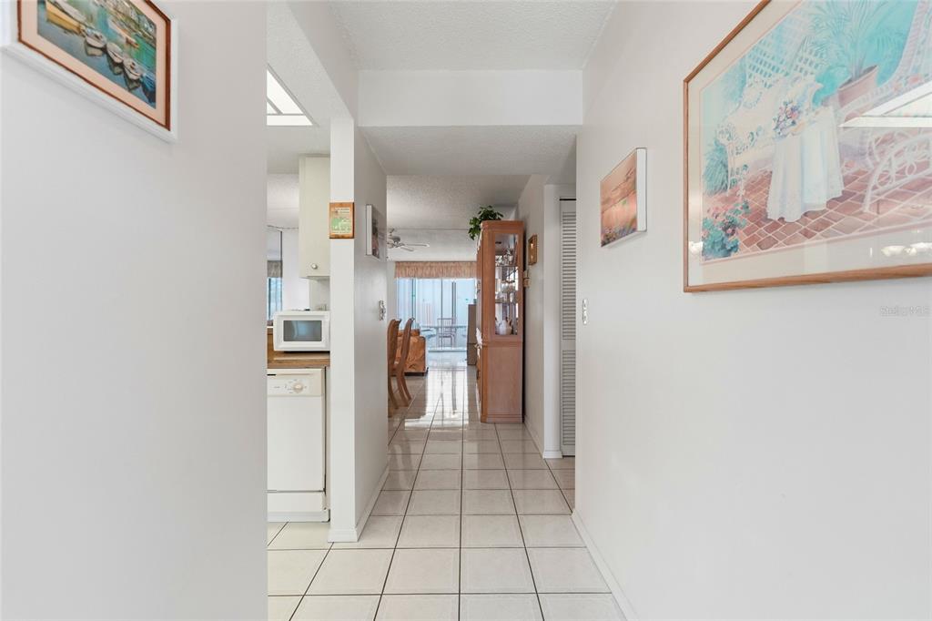 A tiled hallway leads from the foreground toward a kitchen and a dining area — 2609 WOODGATE LANE UNIT K4, SARASOTA, FL