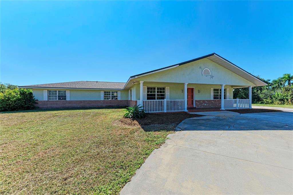 A single-story house with a brick base, light-colored stucco, and a covered front porch — 1499 17TH STREET W, PALMETTO, FL