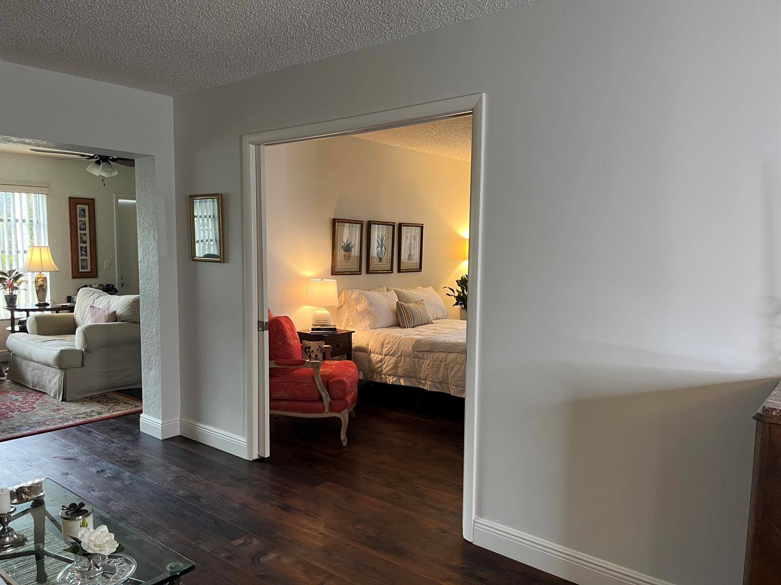 A view from a living area into a bedroom featuring dark wood floors and walls — 2638 Gately Drive E # 112, West Palm Beach FL 33415, WEST PALM BEACH, FL